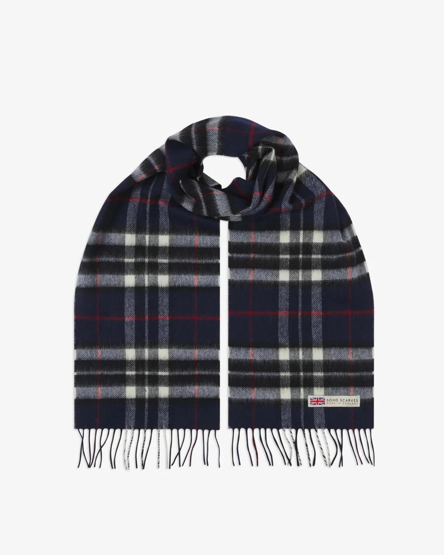 A scarf laid out in a loop, with a grid-like tartan pattern comprised of navy, black, white and red.