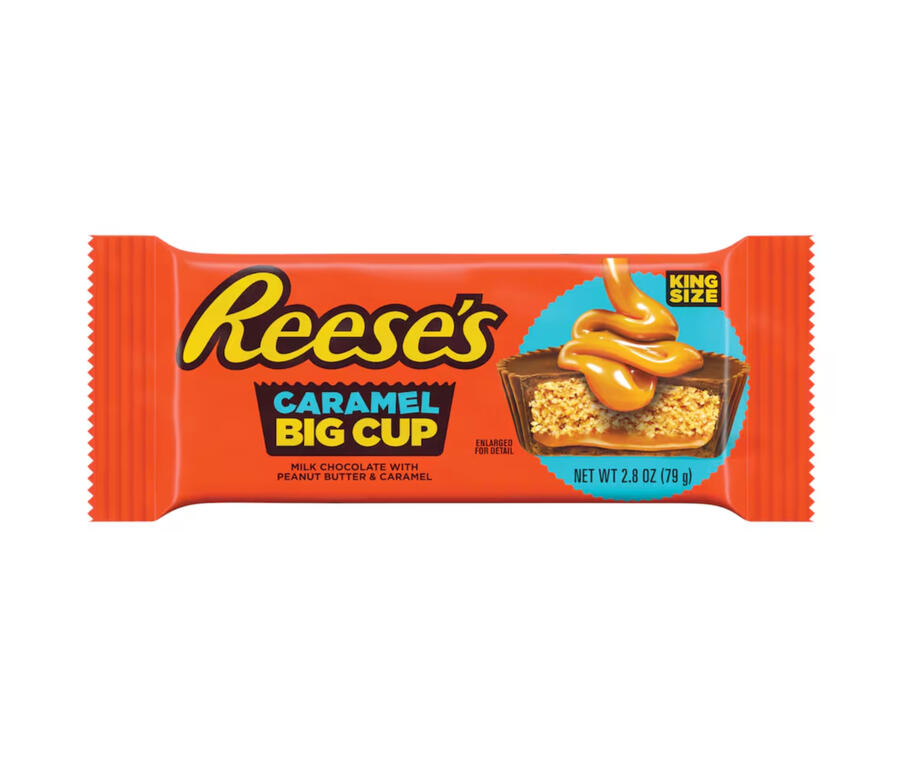 The bright orange packaging of Reese's peanut butter cups. A photo on the packet shows the chocolate-coated cup cut in half, with a thick drizzling of caramel being poured onto it.
